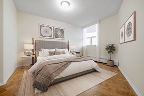 North York apartment for rent - A bedroom with a large bed and a rug on the floor.