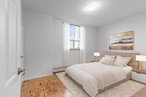 North York apartment for rent - A bedroom with a large bed and a painting on the wall.