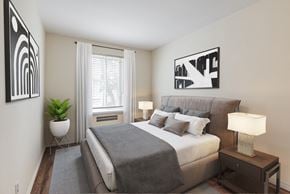 Toronto apartment for rent - A bedroom with a bed, nightstand, and two wall art pieces.