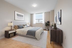 London apartment for rent - A bedroom with a large bed and a nightstand with a lamp.