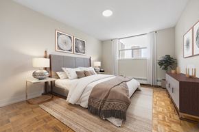 Toronto apartment for rent - A bedroom with a large bed and a wooden floor.