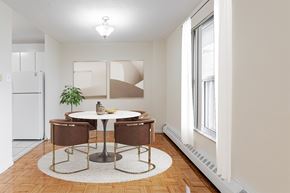 Toronto apartment for rent - A dining room with a white fridge, brown chairs, and a white table.