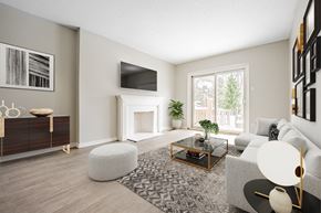 London townhouse for rent - A modern living room with a grey sofa, a coffee table, and a TV on the wall.