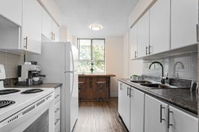 Scarborough apartment for rent - A kitchen with white cabinets and a black stove top.