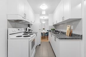 North York apartment for rent - A white kitchen with a stove, oven, and sink.