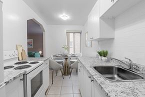 Toronto apartment for rent - A kitchen with a table and chairs in the middle.