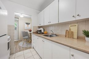 North York apartment for rent - A kitchen with white cabinets and a beige countertop.