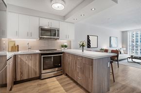 Toronto apartment for rent - A modern kitchen with wooden cabinets and a stainless steel oven.