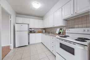 North York apartment for rent - A white kitchen with a stove and refrigerator.