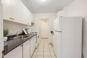North York apartment for rent - A kitchen with white cabinets and a black counter top.
