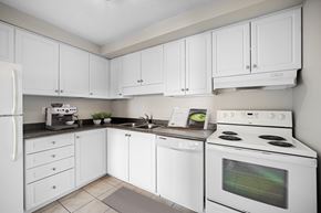 London apartment for rent - A white kitchen with a refrigerator, microwave, oven, and sink.