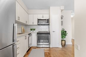 North York apartment for rent - A kitchen with white cabinets and a stainless steel refrigerator.