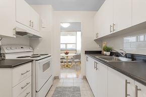North York apartment for rent - A kitchen with white cabinets and black countertops.