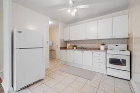North York apartment for rent - A white refrigerator stands in a kitchen with white cabinets and a white stove.
