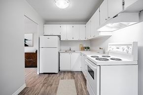 London apartment for rent - A white kitchen with a refrigerator, stove, and cabinets.