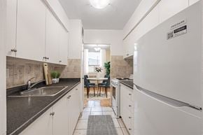 East York apartment for rent - A kitchen with white cabinets and a black counter top.