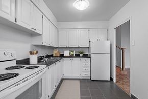 North York apartment for rent - A kitchen with white cabinets and appliances.