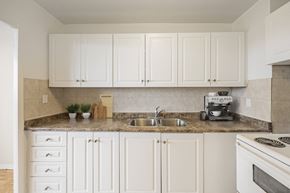 Brampton apartment for rent - A kitchen with white cabinets and a granite countertop.
