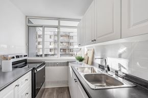 Etobicoke apartment for rent - A modern kitchen with a stainless steel sink and a window overlooking a building.
