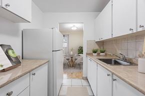 North York apartment for rent - A kitchen with white cabinets and a refrigerator.