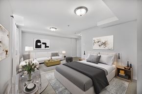 North York apartment for rent - A modern bedroom with a large bed and a glass coffee table.
