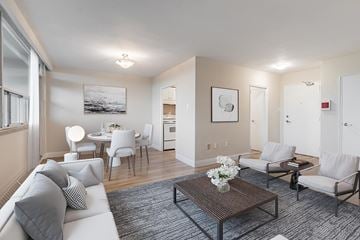 North York apartment for rent - A living room with a white couch, a coffee table, and a painting on the wall.