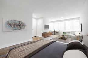 Toronto apartment for rent - A modern bedroom with a large bed and a painting on the wall.