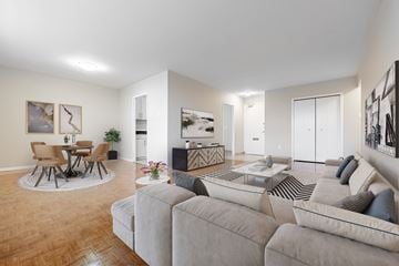 London apartment for rent - A living room with a grey couch and a round table with chairs.