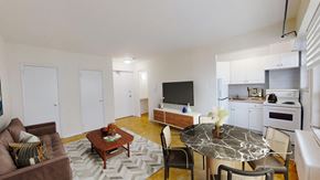 Toronto apartment for rent - A living room with a brown couch, a coffee table, and a television.