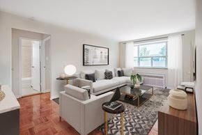 Toronto apartment for rent - A living room with a white couch, a coffee table, and a large window.
