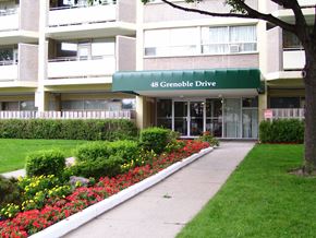 North York apartment for rent - The building at 48 Grenoble Drive is a white apartment complex with a green awning.