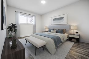 Waterloo apartment for rent - A bedroom with a large bed and a bench in front of it.