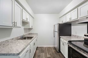 Livonia apartment for rent - A kitchen with white cabinets and a marble countertop.