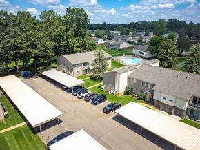 Waterford apartment for rent - A parking lot with cars and a building in the background.