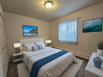 Armada apartment for rent - A bedroom with a large bed and a painting on the wall.