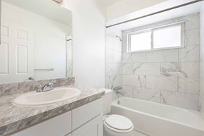 Livonia apartment for rent - A white bathroom with a marble countertop and a white toilet.