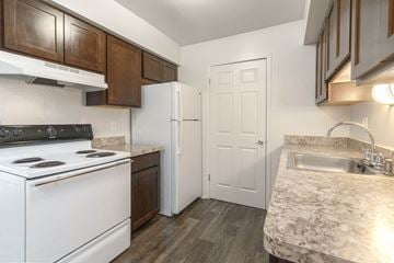 Waterford apartment for rent - A kitchen with a white stove top oven and a white refrigerator.