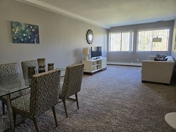 Waterford Township apartment for rent - A living room with a glass table and chairs.