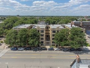 Detroit apartment for rent - an aerial view of a large building surrounded by trees and a parking lot