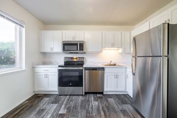Southfield apartment for rent - A kitchen with white cabinets and a wood floor.