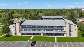 Waterford Township apartment for rent - A large building with a parking lot in front of it.
