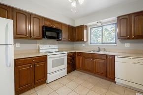 Trenton apartment for rent - A kitchen with brown cabinets and white appliances.