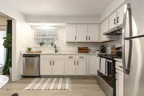 Farmington Hills townhouse for rent - a white kitchen with stainless steel appliances and white cabinets