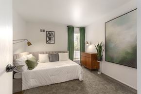 Farmington Hills townhouse for rent - a bedroom with a bed and a painting on the wall