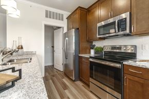 Novi apartment for rent - a kitchen with stainless steel appliances and wooden cabinets