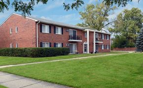 Livonia apartment for rent - A red brick building with a green lawn in front.