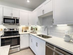 Orlando apartment for rent - a kitchen with white cabinets and stainless steel appliances