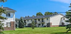 Saginaw apartment for rent - Apartment complex with a white house on the left and a two-story building on the right.