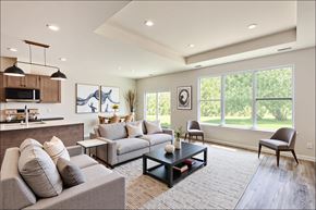 Howell apartment for rent - A modern living room with a grey sofa, a coffee table, and a kitchen area in the background.