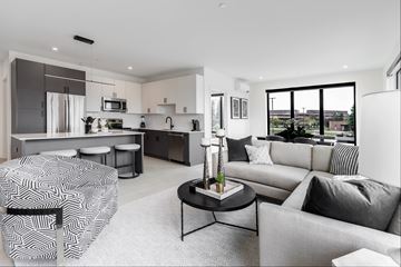 West Bloomfield apartment for rent - A modern living room with a grey sofa and a black and white patterned chair.